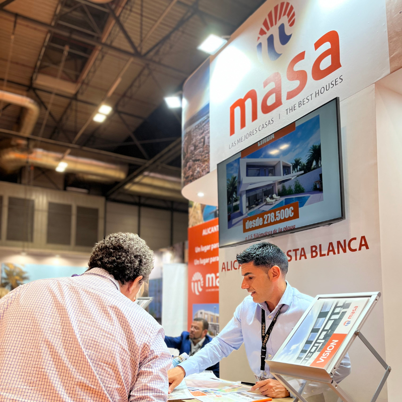 Comercial de MASA asesorando a cliente en feria SIMA